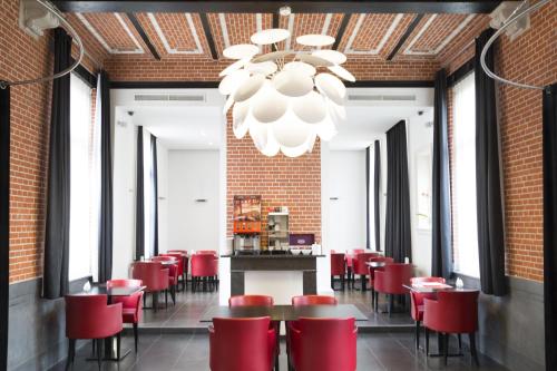 a dining room with red chairs and a chandelier at Zimmerhof Hotel in Lier