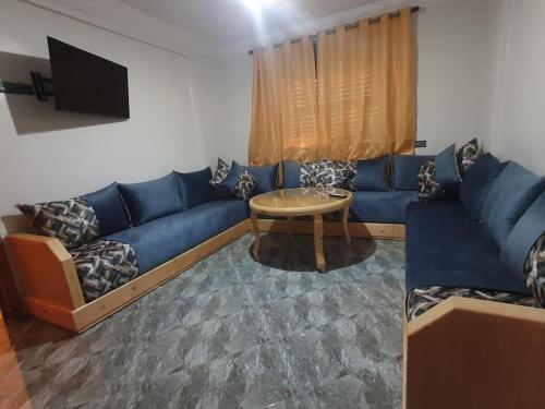a living room with a blue couch and a table at Ayour Beach House 5 in Imsouane