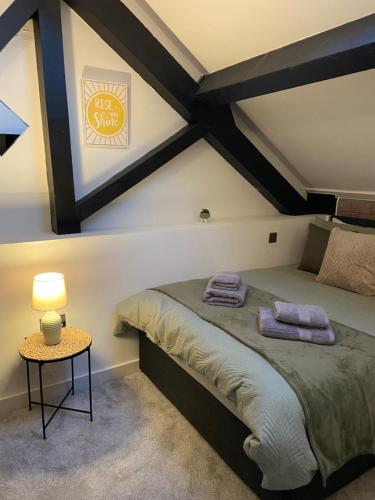 - une chambre avec un lit et une table avec une lampe dans l'établissement Cosy 2 Bed Duplex City Apartment, à Bradford