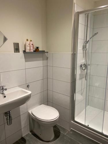 y baño con ducha, aseo y lavamanos. en Cosy 2 Bed Duplex City Apartment, en Bradford