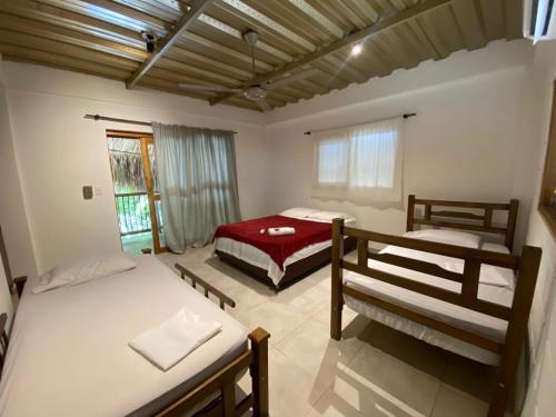 1 dormitorio con 2 camas y manta roja en Bao Bao Hostel, en Palomino
