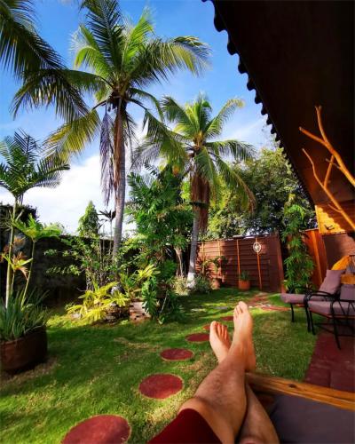 a person with their feet up on a porch with palm trees at Casa Swell Coronado A unique blend of luxury and nature in the hearth of Coronado in Playa Coronado