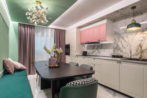 uma cozinha com armários cor-de-rosa, uma mesa e cadeiras em HOLT - All Hemingway's Loves em Bucareste