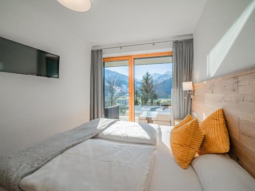 a bedroom with a bed and a couch and a television at Tauern Juwel Top 8 in Hollersbach im Pinzgau