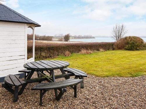 a picnic table and two benches next to a building at 5 person holiday home in Sydals in Trænge