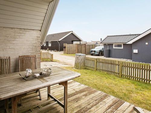 a wooden picnic table on a deck in a yard at 4 person holiday home in Karrebæksminde in Karrebæksminde