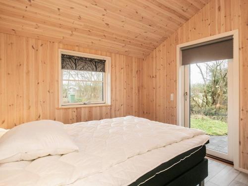 een slaapkamer met een groot bed in een houten kamer bij Holiday home Fjerritslev XXVII in Fjerritslev
