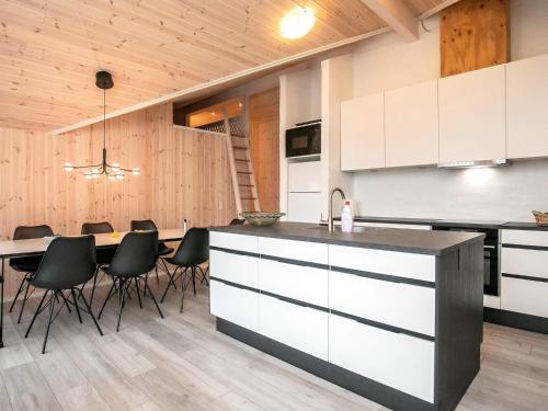 een keuken met witte kasten en een tafel met stoelen bij Holiday home Fjerritslev XXVII in Fjerritslev