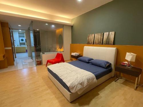 a bedroom with a large bed and a red chair at Stylish Romantic Couples Getaway at KL City 1419 in Kuala Lumpur
