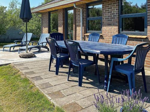 a blue table and chairs on a patio at 8 person holiday home in R m in Lakolk