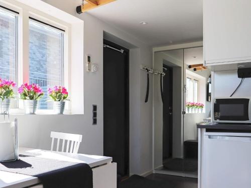una pequeña cocina con fregadero y una ventana con flores en Holiday home VARBERG X en Varberg