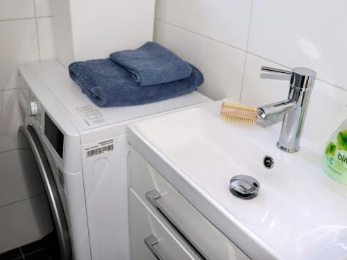 ein Badezimmer mit einem Waschbecken und einer Waschmaschine in der Unterkunft Holiday home VARBERG X in Varberg