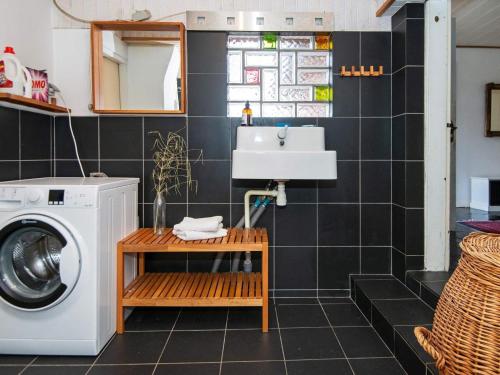 ein Badezimmer mit einer Waschmaschine und einem Waschbecken in der Unterkunft 6 person holiday home in Ringk bing in Ringkøbing