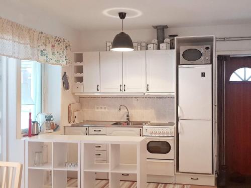 a kitchen with white cabinets and a white refrigerator at 6 person holiday home in LJUSDAL-By Traum in Ljusdal