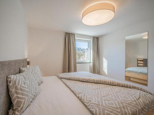 ein Schlafzimmer mit einem Bett und einem großen Spiegel in der Unterkunft Apartement am Lift XL in Hopfgarten im Brixental