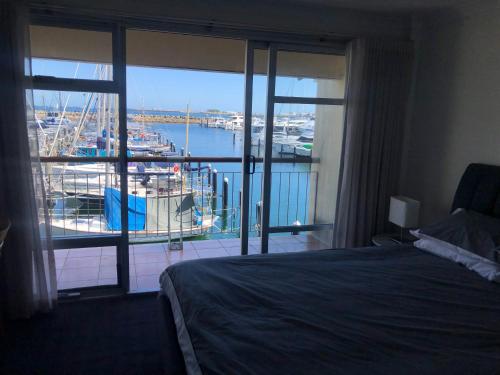 a bedroom with a bed and a view of a marina at Fremantle Harbour Townhouse in Fremantle