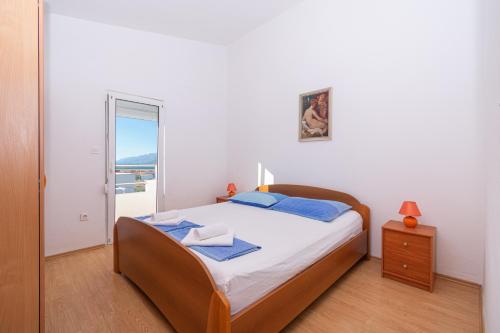 ein Schlafzimmer mit einem Bett und einem Fenster in einem Zimmer in der Unterkunft Apartments with a parking space Razanac, Zadar - 6919 in Ražanac