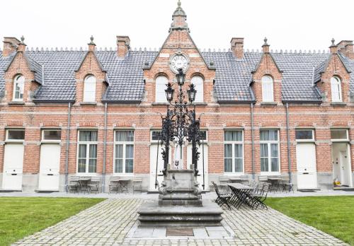 a large brick building with a clock on a fountain at Zimmerhof Hotel in Lier