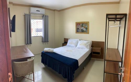 a small bedroom with a bed and a mirror at Hotel Estrela in Castanhal