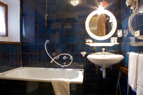 クールマイヨールにあるホテル ドローネの青いタイル張りのバスルーム(バスタブ、シンク付)
