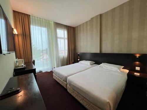 a hotel room with a bed and a large window at SSL Traders Hotel in Taiping