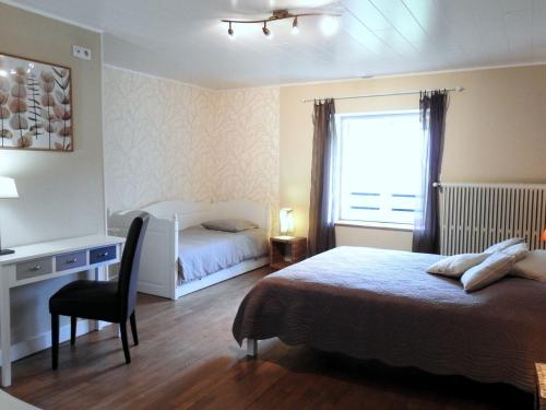 a bedroom with two beds and a desk and a window at Gîte de caractère avec jardin, terrasse, et équipements pour enfants à Saint-Blin - FR-1-611-31 in Saint-Blin