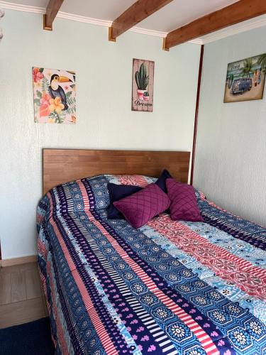 - une chambre avec un lit doté d'une couette dans l'établissement Arránquese de la lluvia y disfrute de días soleados en la Playa Los Molles con buen clima en acogedora cabaña, à Los Molles