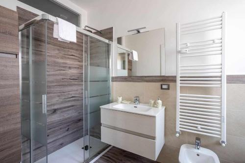 米蘭的住宿－Milano City Apartments - Parking and Comfort - Spacious Apt up to 8 Pax，一间带水槽和玻璃淋浴的浴室