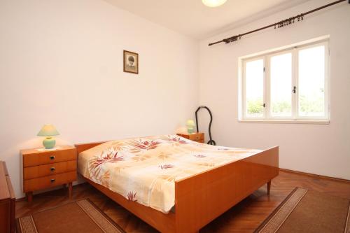 a bedroom with a bed and a window at Family friendly seaside apartments Ugljan - 828 in Ugljan