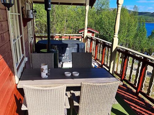 7 person holiday home in JARFJORD في Karpbukt: طاولة على شرفة مع وجود شمعتين عليها