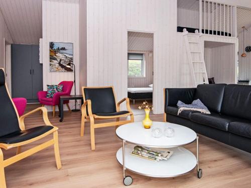 a living room with a black couch and chairs at 8 person holiday home in Glesborg-By Traum in Glesborg