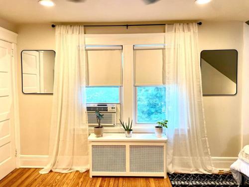 a bedroom with a window and a table with plants at Immaculate, Newly Renovated 1 Bedroom Apt Near NYC in Hawthorne