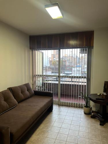 a living room with a couch and a large window at Apartamento El Colibri in Cordoba