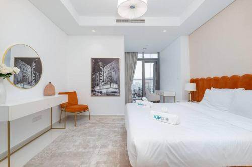 a white bedroom with a large bed and a mirror at Opulent Hollywood Styled Flat in Paramount Tower in Dubai