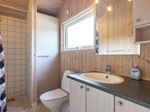 La salle de bains est pourvue d'un lavabo, de toilettes et d'une fenêtre. dans l'établissement Three-Bedroom Holiday home in Ålbæk 21, à Ålbæk