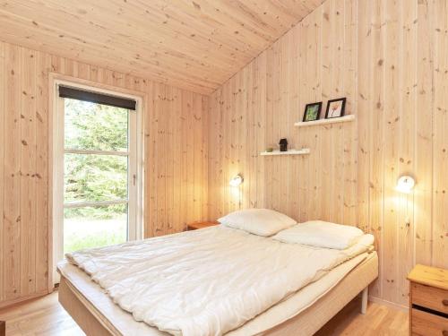 una camera con un letto su una parete in legno di Three-Bedroom Holiday home in Ålbæk 21 ad Ålbæk