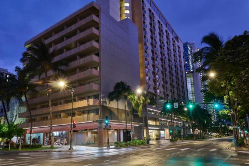 a large building on a city street at night at Waikiki Malia in Honolulu