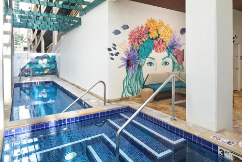 a swimming pool with a mural of a woman at Waikiki Malia in Honolulu