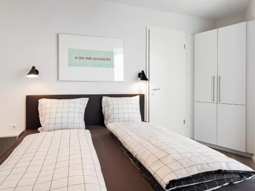 een bed in een slaapkamer met witte kasten bij Apartment Wendtorf III in Wendtorf