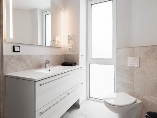 een witte badkamer met een wastafel en een toilet bij Apartment Wendtorf III in Wendtorf