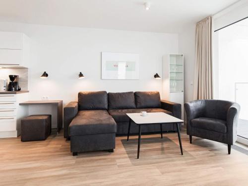 Una sala de estar con un sofá, una mesa y sillas. en 6 Personen Ferienhaus in Wendtorf, en Wendtorf