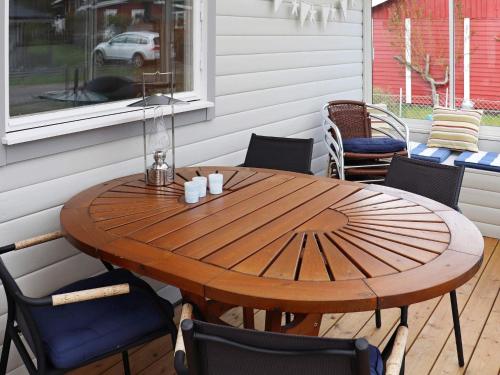 una mesa de madera y sillas en un patio en 5 person holiday home in MELLBYSTRAND en Mellbystrand