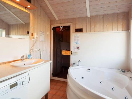 y baño con bañera y lavamanos. en Three-Bedroom Holiday home in Grömitz 4, en Grömitz