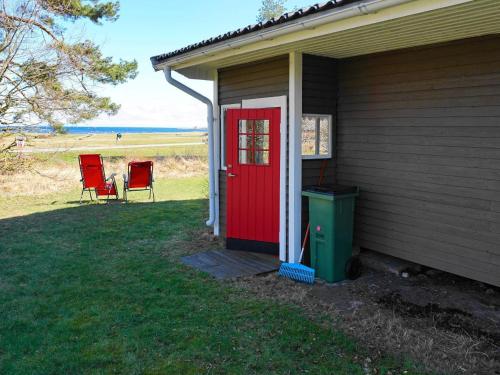 a house with a red door and two chairs at 8 person holiday home in BERGKVARA in Bergkvara