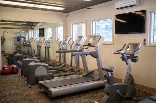 a gym with rows of tread machines in a room at Waikiki Malia in Honolulu