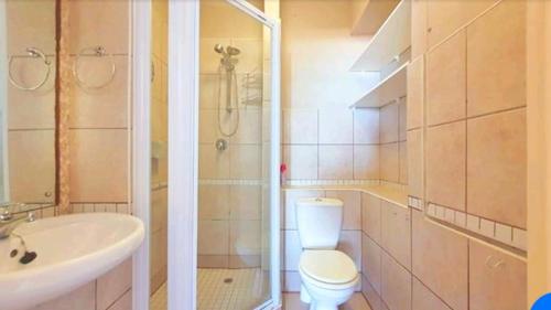 a bathroom with a toilet and a sink and a shower at Beachside 3 bed apartment with stunning seaviews in Amanzimtoti