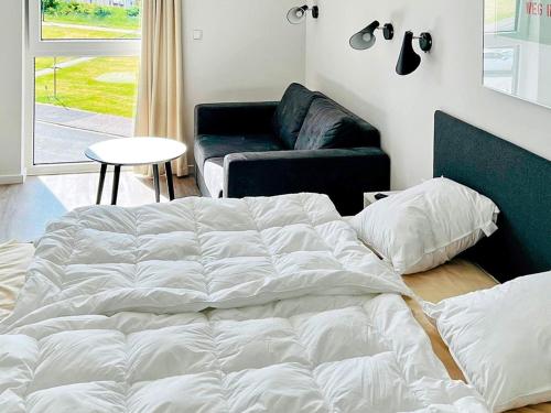 a large white bed in a room with a couch at Moderne Wohnung mit direktem Meerblick in Wendtorf