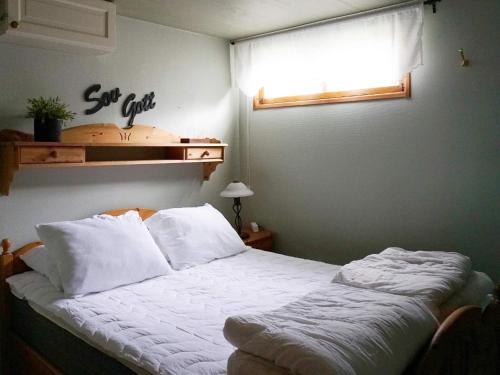 Schlafzimmer mit einem Bett mit weißer Bettwäsche und einem Fenster in der Unterkunft Holiday home öSTHAMMAR II in Östhammar