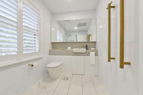 un bagno bianco con un water e un lavandino di Premium Villa 2br Malvasia at Cypress Lakes - Modernised Comfort a Pokolbin