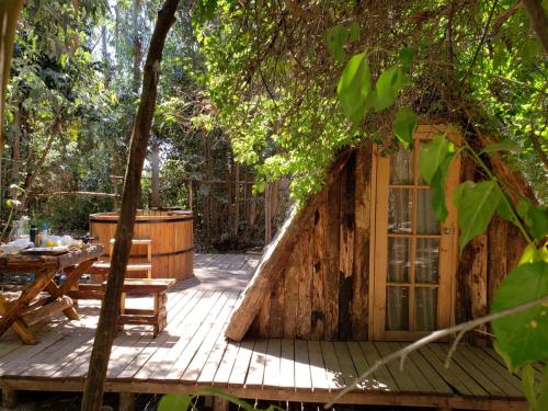 een hut in het bos met een tafel en een raam bij Bosques del Paico in El Monte
